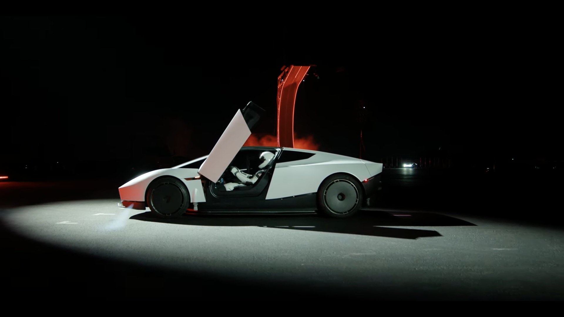 Tesla Roadster dengan pintu terbuka di bawah sorotan lampu
